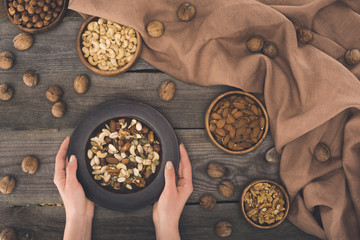 bowl with various nuts in hands