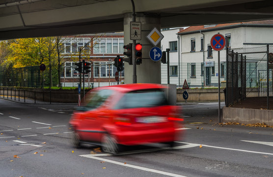 Verkehrsdelikt Rotlichtverstoß rotes Auto fährt bei Rot über eine Ampel - Red light offence Red car drives over a traffic light at red light