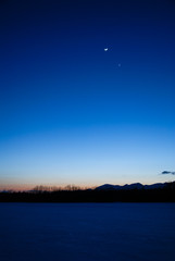 Obraz premium 雪原の上の月と金星（北海道・十勝）