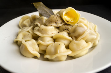 Russian dumplings in a white plate on a black background