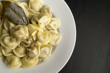 Russian dumplings in a white plate on a black background