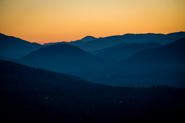 amazing collection of mountains in the morning autumn light of the sun that almost came up in the gold sky