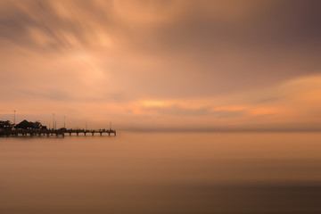 Fototapeta na wymiar Fishing dock in calm sea and smooth sky
