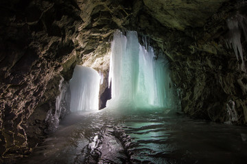 Fototapeta na wymiar Underground mine shaft tunnel gallery witn ice frozen stalactites stalagmites