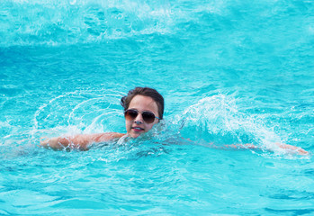 Naklejka premium The girl is swimming in the pool