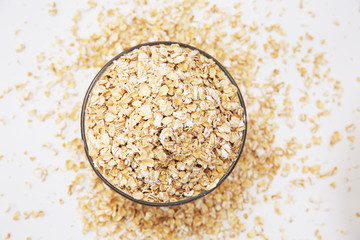 oat flakes in a transparent bowl on a white background