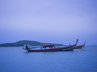 Obraz premium The classical wooden style of boats are parking in the middle of the sea between the shore and island such a nice moment to be captured at Phuket.