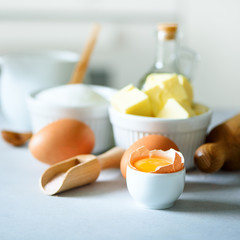 Baking background. Cooking ingredients for dough, eggs, flour, sugar, butter, rolling pin on white style kitchen. Copy space