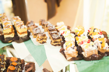 Delicious and tasty dessert table with cupcakes shots at reception closeup