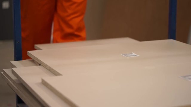 Manufacturing of furniture. The companion carries pieces of furniture on the cart. Sorting after a sawing