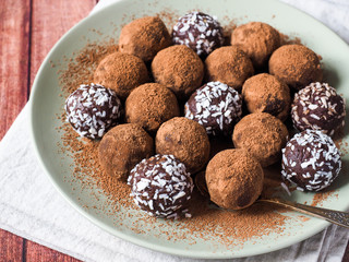 Homemade chocolate truffles with cocoa and coconut on the plate