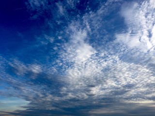 Naklejka na ściany i meble Clouds rolling in over a blue sky.