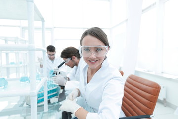 Investigator checking test tubes, Woman wears protective goggles