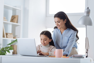 Delighted nice girl working on the laptop