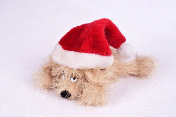 toy dog ​​in a Christmas hat on an abstract background