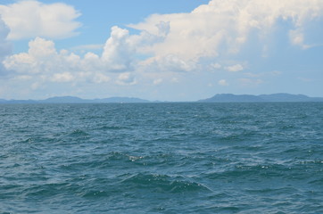 Fototapeta premium The vastness of the ocean is depicted in this picture with an expanse of the blue water and white clouds