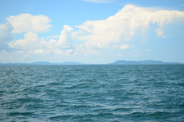 The vastness of the ocean is depicted in this picture with an expanse of the blue water and white clouds