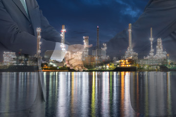 Businessmen handshaking in front of oil refinery plant. Agreement, Collaboration and  for oil and gas business concept.