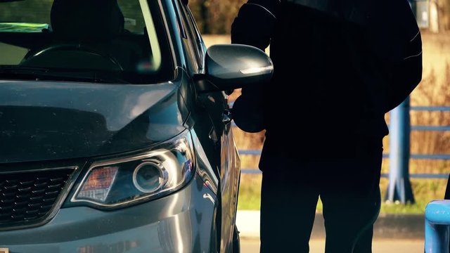Unrecognizable man refuels his car at the filling station