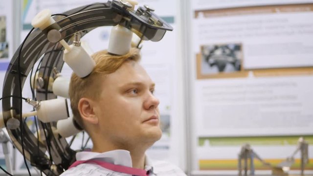 Brain research. The power of thought. Man controls remotely with the help of the brain. Man wired to an EEG machine or electroencephalograph which produces a graphical record of electrical activity