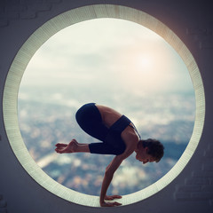 Beautiful sporty fit yogi woman practices yoga asana Natarajasana - Lord Of The Dance pose in a round window © sandsun