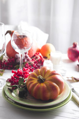 Thanksgiving dinner table setting with pumpkins,