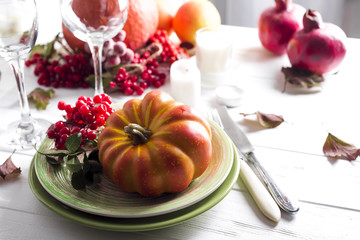 Thanksgiving dinner table setting with pumpkins,