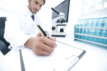 scientist makes a note of experiment in the laboratory