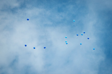 Balloons blue colors flying in the blue sky with clouds