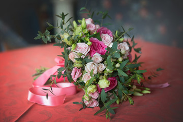 Wedding bouquet flowers on the table with a red tablecloth in the interiors