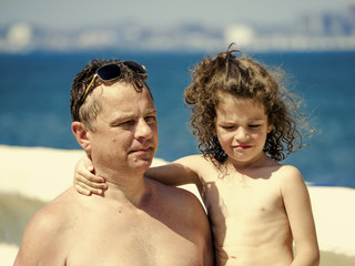 Father with a young son on beach.  Happiness Baby on the fathers hands