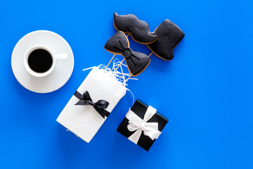 Happy Father's day cards. Black tie, mustache and hat cookies and gift. Blue background top view copyspace