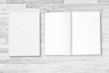 Blank white notebook cover with open notebook page on white wooden table with clipping path on notebook for mockup designs