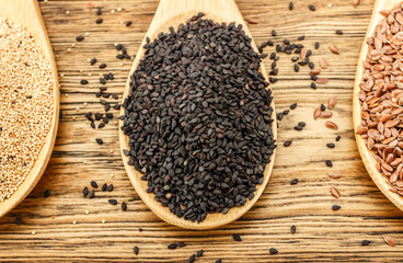 Seeds of black sesame. For sprouting. Healthy diet. A treasure trove of vitamins. Amaranta Wooden spoon with, spoon with flax. Close-up.