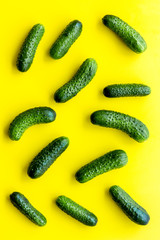 Fresh cucumbers pattern on yellow background top view