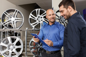 customer and salesman at car service or auto store