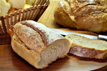 Delicious breads on wooden table seen from above.