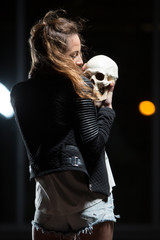 Young beautiful woman holding human skull outdoors