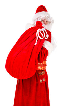 Portrait of Real Santa Claus carrying big bag from behind, isolated on white background