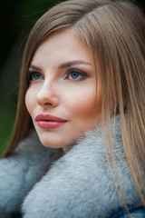 Beautiful young blonde woman wearing fur autumn coat