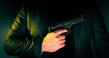 Hitman in suit  holds gun in front of himself