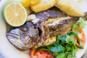 Grilled sea bream with poatatoes, tomatoes and lemon
