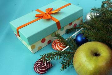 Christmas candies on blue background with gift. fir-tree branches