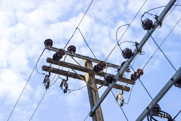 Electric pole connect to the high voltage electric wires on against bright blue sky