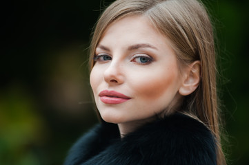 Beautiful young blonde woman wearing fur autumn coat