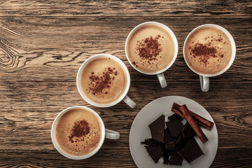 Coffee Rhapsody. Cup of coffee with chocolate. The view from the top. Place for Your Logo. Hot and refreshing coffee on a wooden table. Americano with cinnamon.
