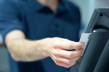Credit card payment terminal in store. Seller draws up credit card purchases. close-up of a seller with a credit card