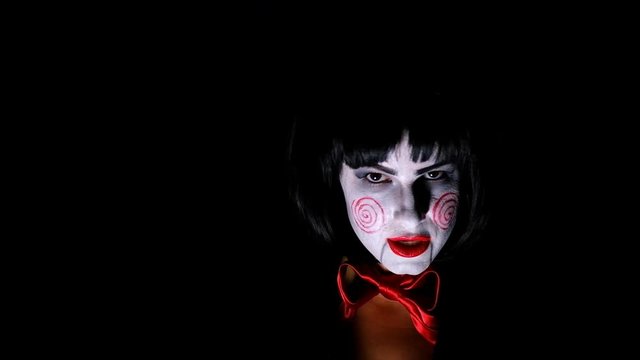 Girl with make-up in nightmare style sings on a black background