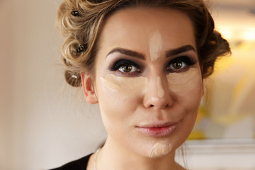 Fototapeta premium Pretty woman with dark smokey eyes makeup and highlighter under eyes and on the nose