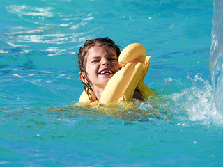 Child rest in the pool in summer